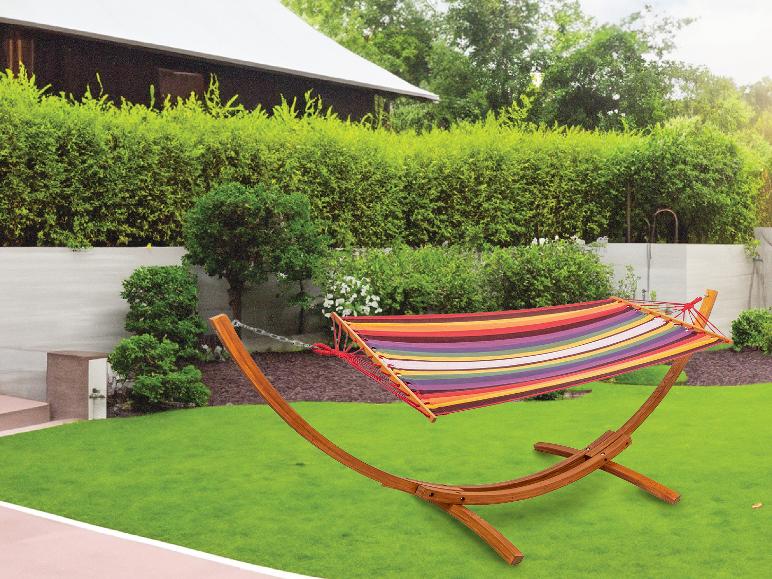 Hamac multicolore sur un support en bois dans un jardin.