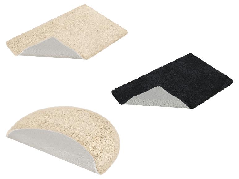Deux tapis de bain rectangulaires beiges et noirs, et un tapis de bain semi-circulaire beige.