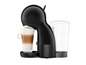 Une machine à café Nespresso noire prépare un cappuccino dans un verre.
