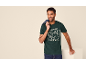 Homme en t-shirt vert foncé avec un imprimé Père Noël et un jean