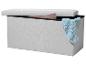 Banc de rangement gris clair avec couvercle ouvert, couverture bleue et rose