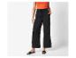 Pantalon large noir et sandales plates : look décontracté élégant.