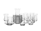 Verres à thé en verre transparent avec soucoupes, certains empilés, sur fond blanc.