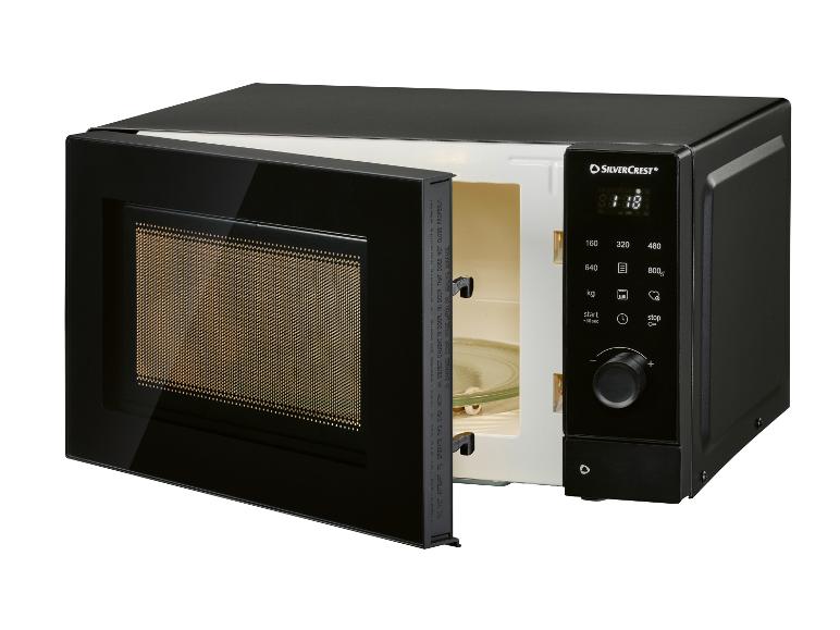 Four à micro-ondes noir avec porte ouverte, affichage numérique et panneau de commande.