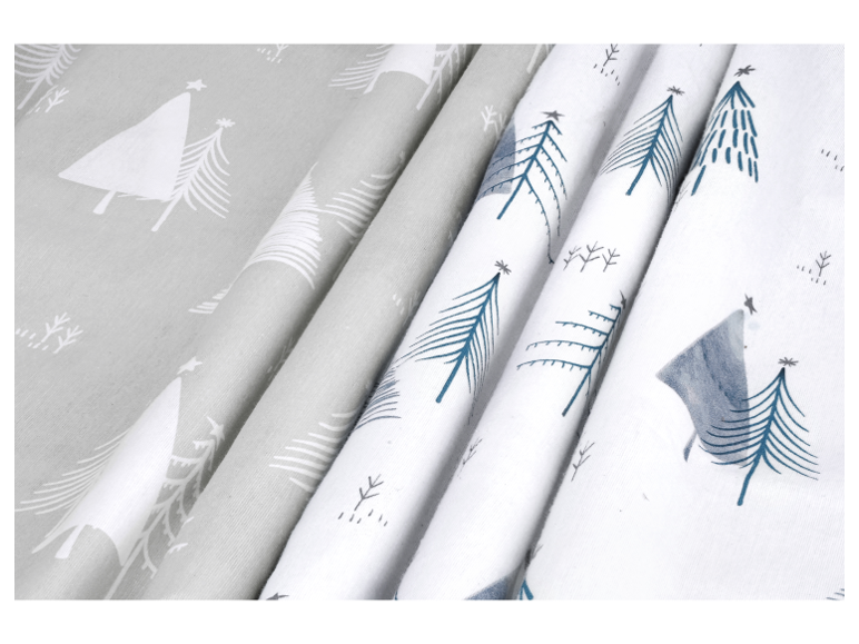 Tissus avec motifs de sapins de Noël en gris et blanc, et blanc avec des sapins bleus.