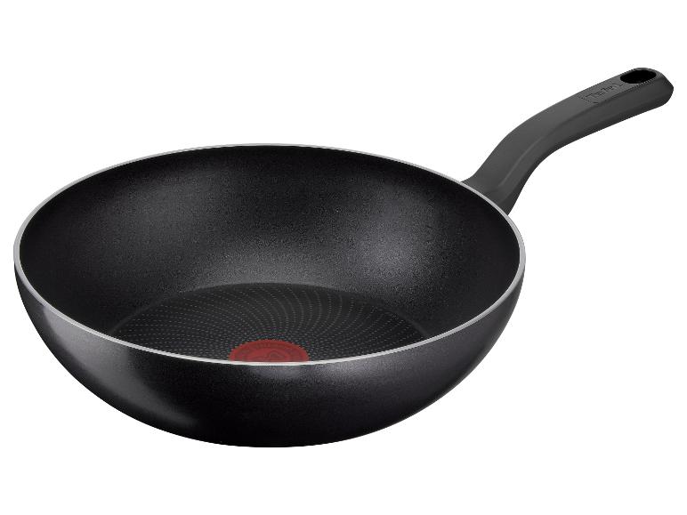 Wok noir avec poignée et indicateur de température rouge au fond.