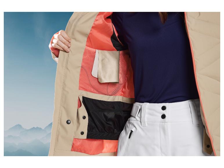 Veste de ski beige avec doublure rose et pantalon blanc.