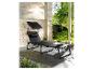 Une chaise longue noire avec un parasol pour le jardin.