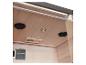 Intérieur d'un sauna en bois avec plafonniers, haut-parleurs et grille de ventilation.