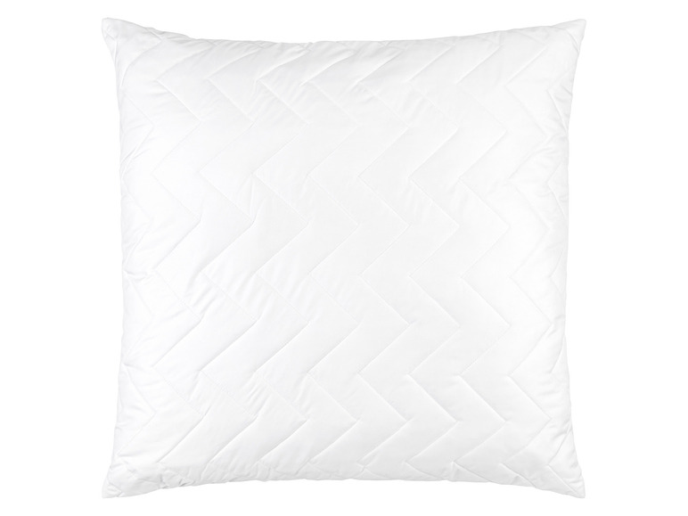 Un oreiller blanc avec un motif matelassé.