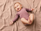 Un bébé allongé sur une couverture tricotée.