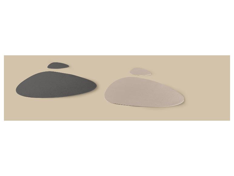Deux ensembles de sous-verres en cuir synthétique, un gris foncé et un beige clair, sur fond beige.
