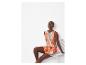 Ensemble short et top d'été à motifs abstraits orange et vert.