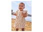 Bébé en robe florale beige sur la plage