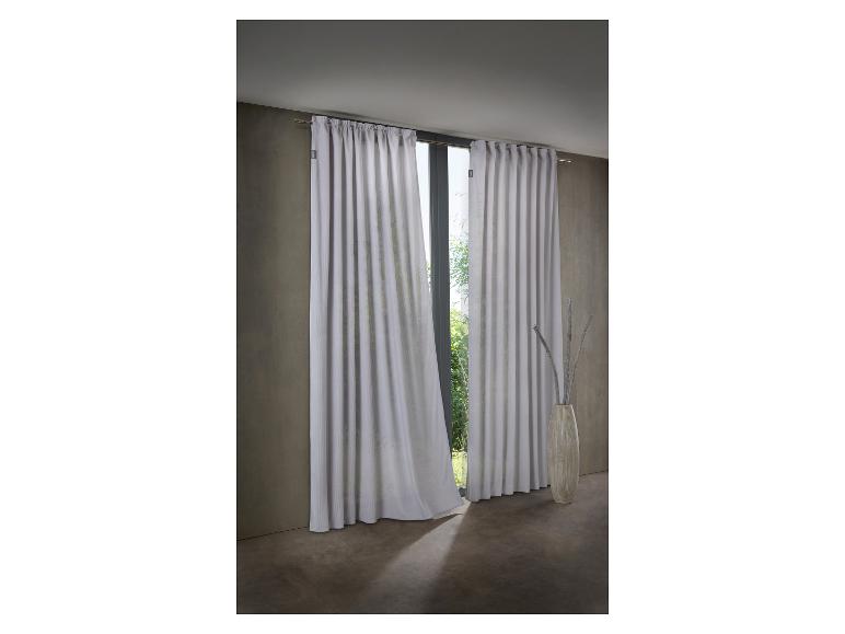 Rideaux gris clair avec un motif subtil, suspendus à une tringle, devant une fenêtre avec un vase décoratif.