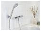 Ensemble de douche chromé moderne fixé à un mur de carrelage blanc.