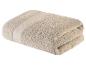 Serviette de bain beige, douce et moelleuse.