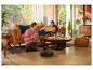 Robot aspirateur nettoyant le sol pendant qu'un couple mange de la pizza et lit dans un salon douillet.