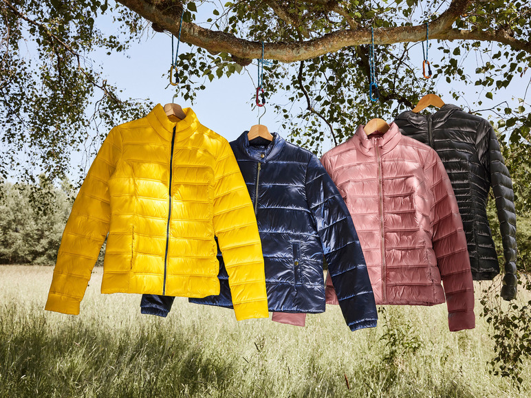 Quatre vestes différentes accrochées à une branche : jaune, bleu foncé, rose et noire.