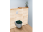 Toilettes avec abattant à feuilles dorées, mur en bois clair et étagère.