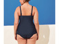 Une femme porte un maillot de bain bleu foncé avec des bretelles spaghetti.