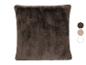 Coussin en fausse fourrure marron avec trois échantillons de couleur à côté.