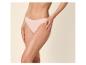 Femme en culotte couleur chair, les mains sur les cuisses.