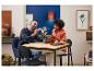 Un homme et une femme assemblent un set LEGO Orchidée sur une table en bois.