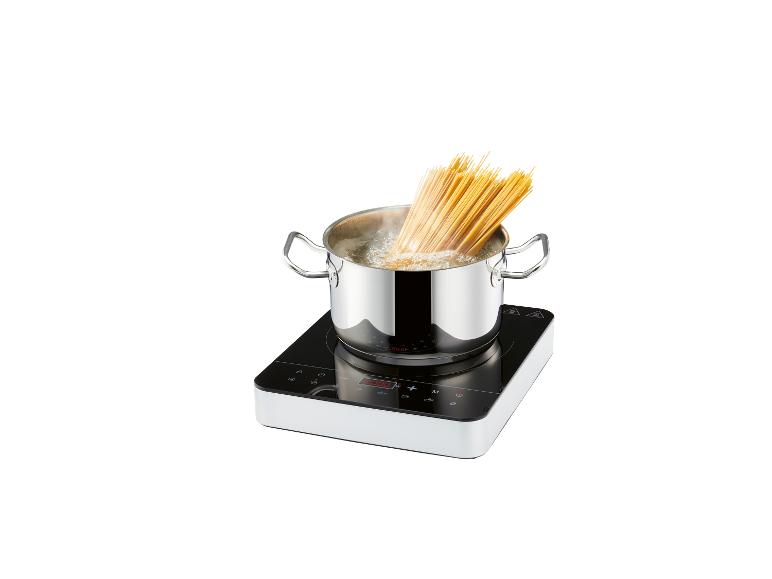 Une plaque de cuisson avec une casserole d'espaghettis bouillants.