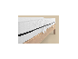 Matelas à ressorts ensachés blanc sur un cadre de lit en bois.