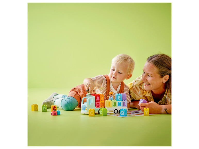 Un enfant et un adulte jouent avec des blocs LEGO DUPLO avec des lettres.