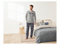 Homme en pyjama à carreaux et un t-shirt gris avec l'impression 'Local Craft'.