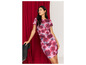 Une femme dans une robe rose à imprimé floral rouge