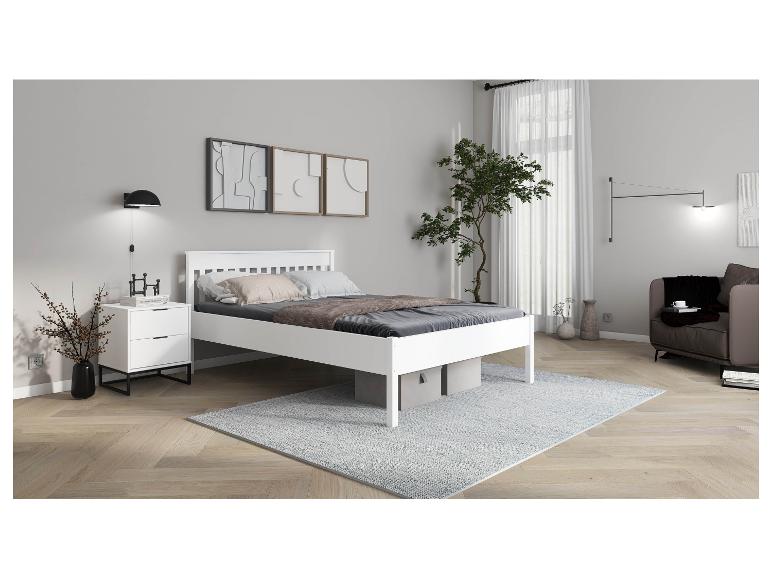 Chambre moderne blanche avec lit et table de chevet.