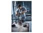 Un homme utilise une perceuse-visseuse sans fil Parkside pour percer une table de travail.