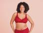 Une femme porte un ensemble de lingerie rouge en dentelle.