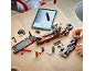 Enfant construisant un camion transporteur et une voiture de course jouets avec des instructions numériques.
