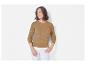 Une femme porte un pull en maille beige à torsades avec un petit logo.