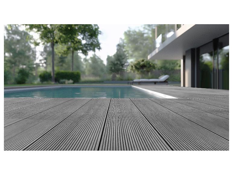 Terrasse composite grise au bord d'une piscine avec une maison moderne en arrière-plan.
