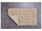 Tapis de bain beige à carreaux sur un sol en carrelage gris