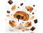 Un croissant au chocolat qui éclate en morceaux avec du chocolat fondu sur fond blanc
