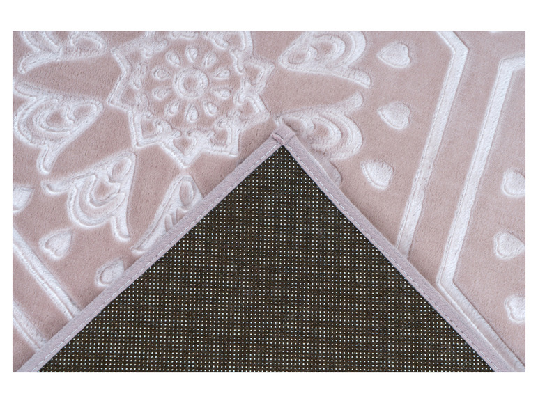 Un tapis rose avec un motif en relief blanc et un dos antidérapant.