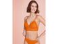 Une femme porte un soutien-gorge et une culotte orange en dentelle.