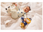 Bébé portant une tenue blanche et bleue avec un lion en peluche jaune.
