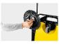 Personne remplaçant la brosse d'une balayeuse jaune
