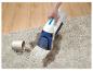 Nettoyeur de taches portable nettoyant un tapis avec une tasse renversée.