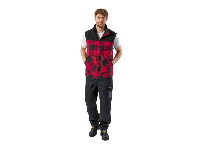 Homme en gilet à carreaux rouge et noir, pantalon de travail noir et bottes.