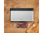 Appareil de mise sous vide avec des aliments sous vide sur une table en bois