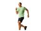 Homme courant en t-shirt vert et short noir.