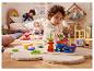Un enfant joue avec des jouets en bois sur un tapis moelleux dans sa chambre d'enfant.